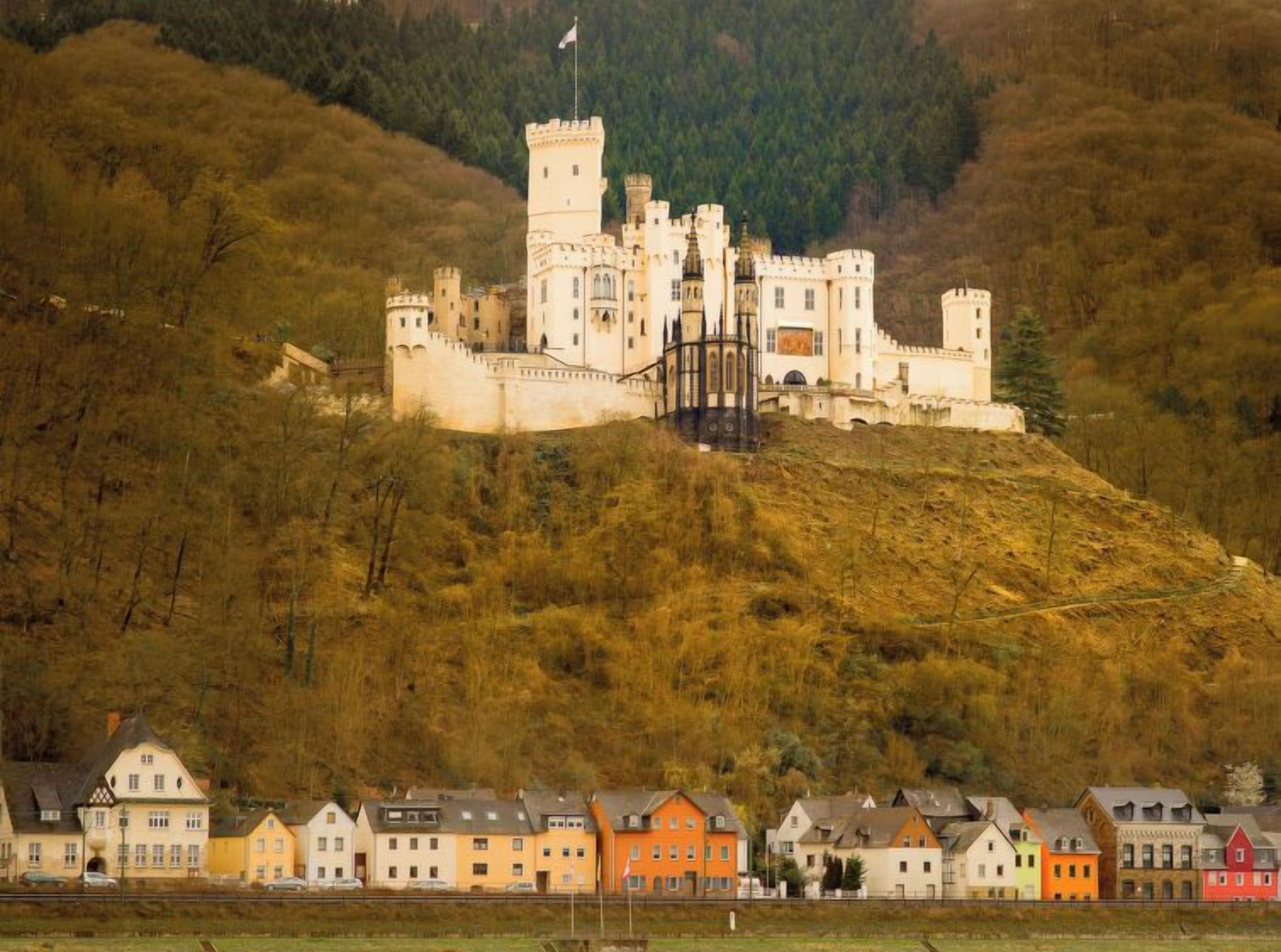 A castle on a hill with a town in the foreground.