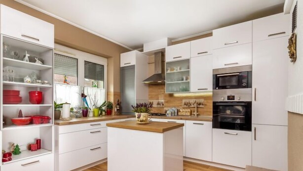 A modern kitchen with white cabinetry, a central island, and built-in appliances including a microwave and oven. - Vacation home Colore by Interhome (Balatonmariafurdo)