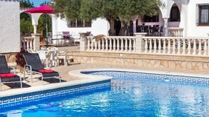 A pool area with lounge chairs, a pergola, and a dining area with outdoor seating. - Rustical Mont Roig by Interhome (Miami Platja)