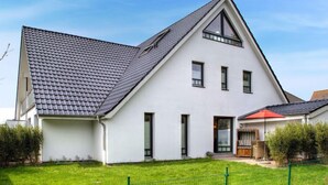 A modern two-story house with a sloped roof, a front porch, and a fenced yard. - Witthuus-Baltrum by Interhome (Norddeich)