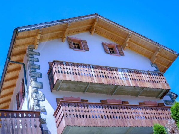 A building with a wooden balcony and a stone facade.