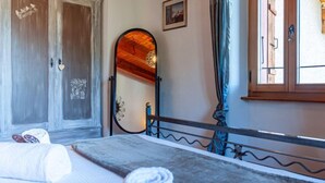 A bedroom with a bed, a wardrobe, a mirror, and a window with curtains. - Le Dahu by Interhome (Nendaz)