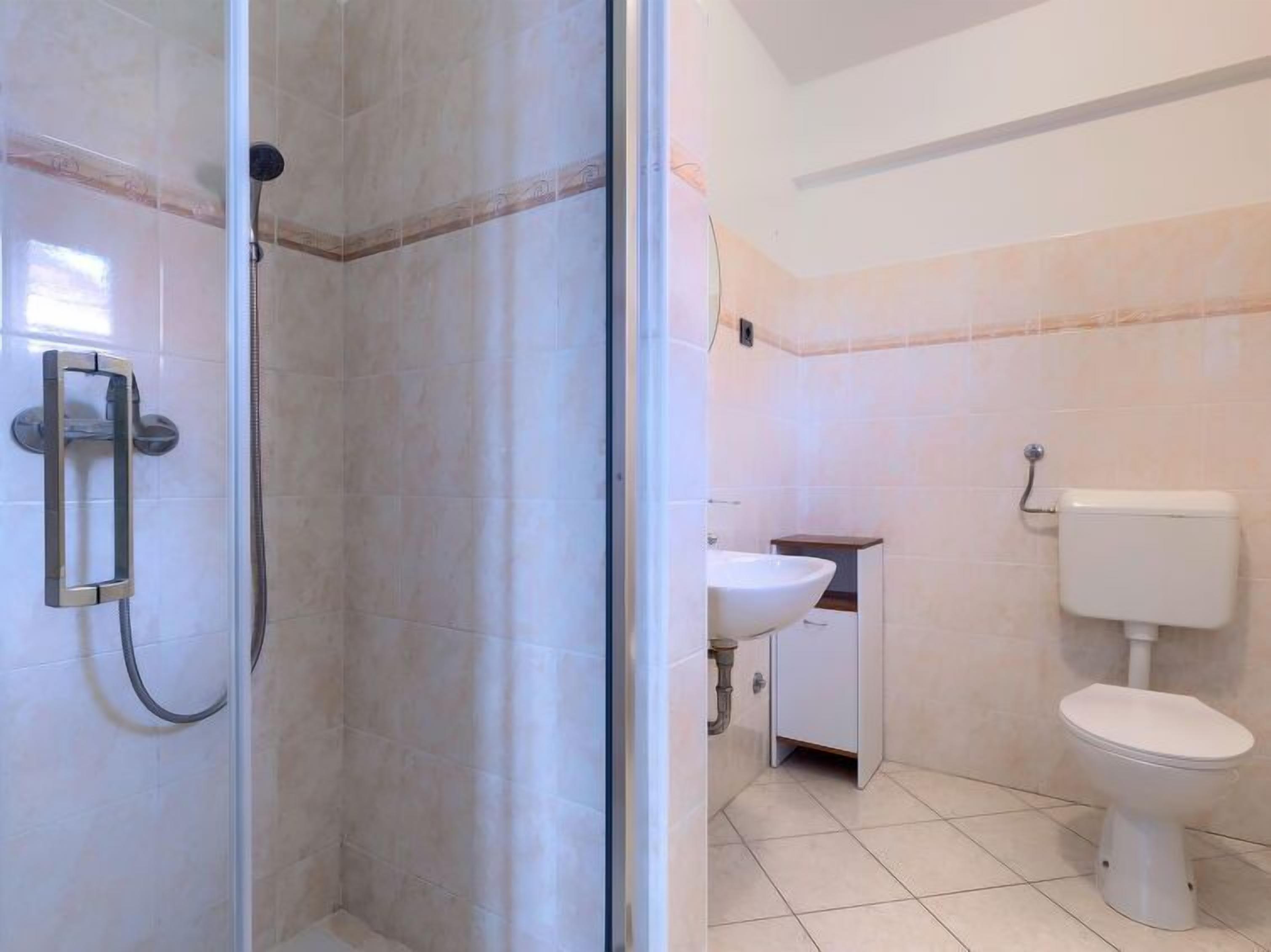 A bathroom with a shower, toilet, and sink.