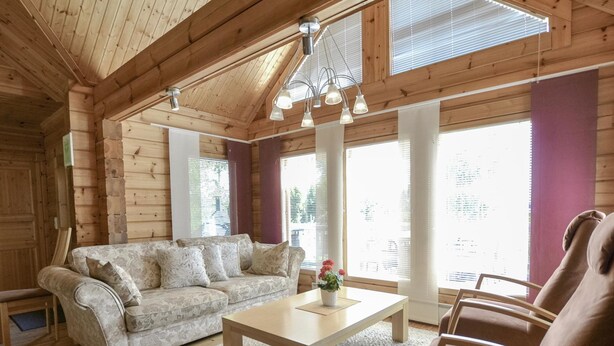 A log cabin interior with a sofa, a coffee table, and a chair. - Kannelpirtti 2 by Interhome (Liperi)