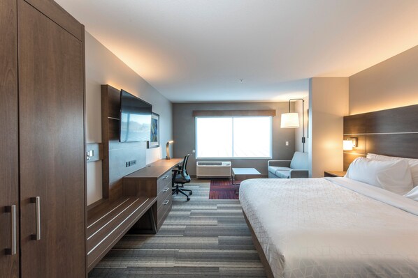 A hotel room with a large bed, a desk with a chair, a TV mounted on the wall, and a window providing natural light. - Holiday Inn Express & Suites Phoenix North - Happy Valley by IHG (Phoenix)