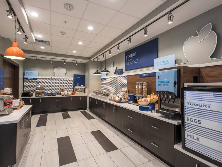 A modern breakfast area with a self-serve station, a yogurt dispenser, and a digital menu board.