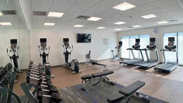 A fitness center with treadmills, elliptical machines, and free weights.