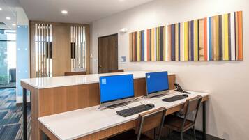 A modern office space with two desks, each with a computer and keyboard, and a telephone.