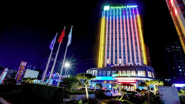 A multi-story hotel with a prominent vertical light display and a sign reading 'Holiday Inn Express'.