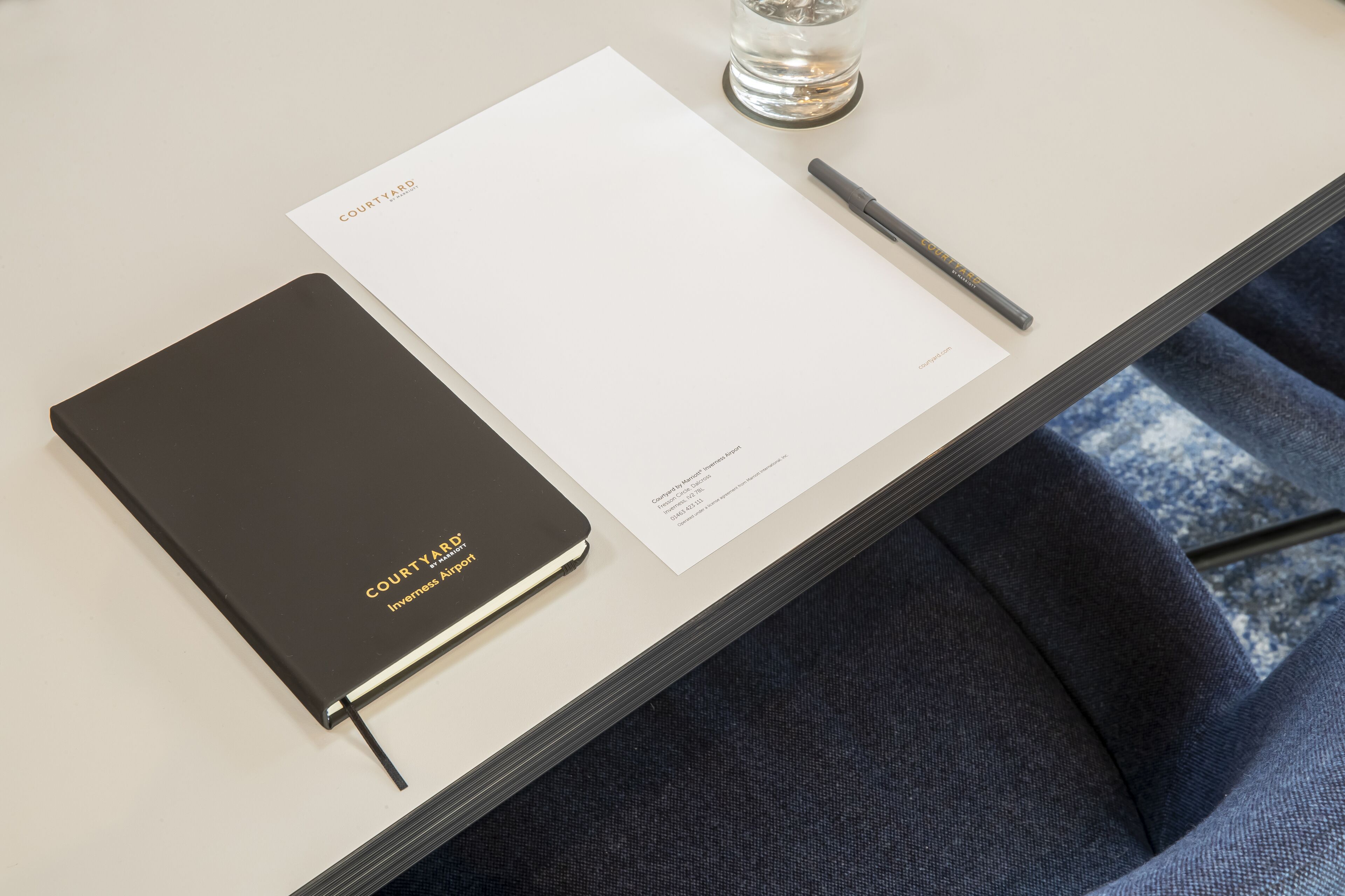 Un cuaderno con la etiqueta "COURTYARD" y una hoja en blanco sobre una mesa.