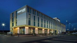 A Courtyard by Marriott hotel with a modern design, large windows, and a well-lit entrance area. - Courtyard by Marriott Inverness Airport (Inverness)