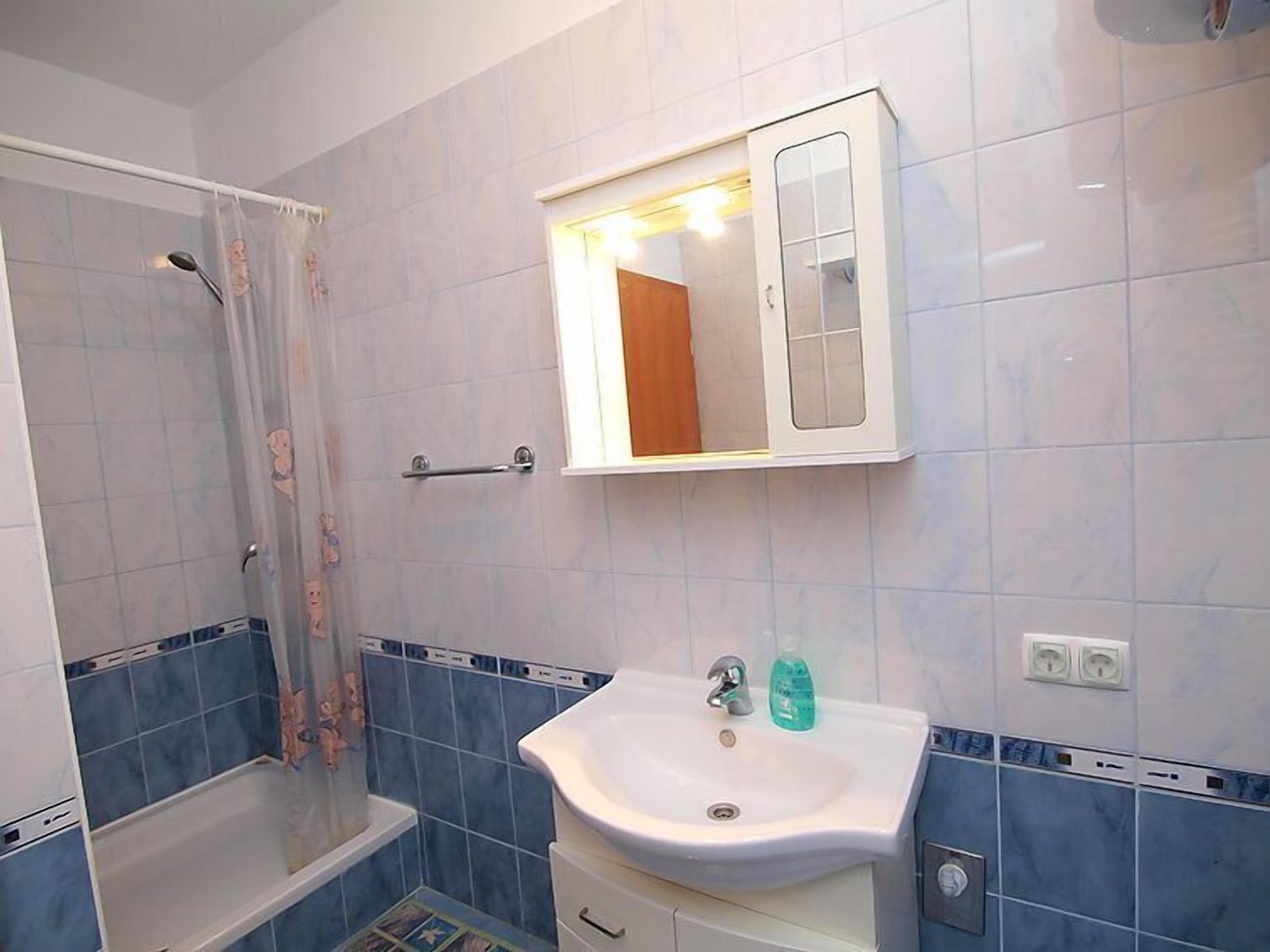 Un baño con ducha, lavabo y espejo.
