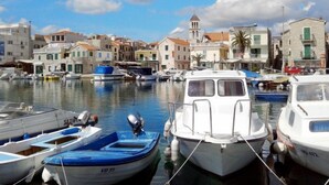 Una marina con barche ormeggiate, una chiesa con un campanile e edifici con balconi.
