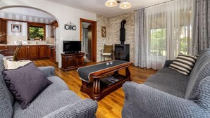 Un salon chaleureux avec une cheminée, un téléviseur et un coin repas doté de meubles de rangement en bois.