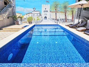 Relax by the pool surrounded by Mediterranean architecture and a stunning castle view.