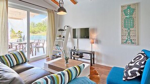 A modern living room with a sofa, a coffee table, a TV, and a bookshelf. - Vacation home Ravan by Interhome (Motovun)
