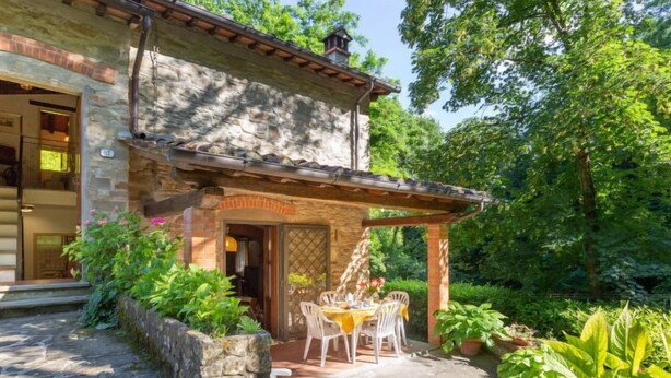 A stone building with a covered patio area featuring a table and chairs. - La Ripresa by Interhome (Vicchio)