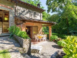 A stone building with a covered patio area featuring a table and chairs. - La Ripresa by Interhome (Vicchio)