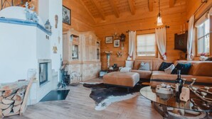 Ein gemütliches Blockhaus-Interieur mit Kamin, Holzmöbeln und einem Cowboysteppich.