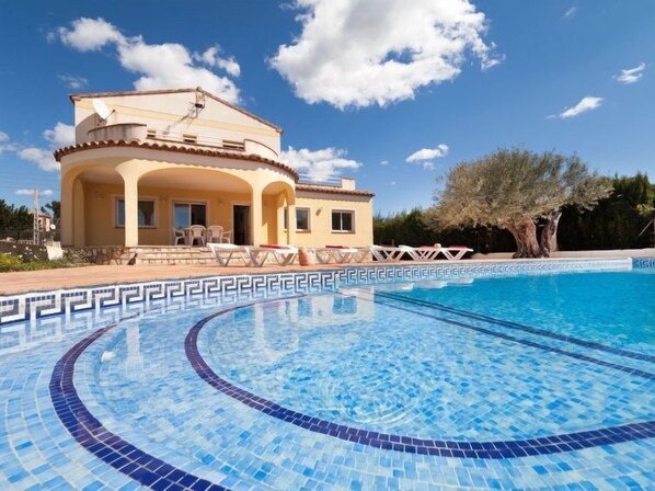 Une maison à deux étages avec une piscine à l’avant.