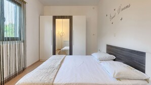 Un dormitorio con una cama grande, un armario y un espejo.