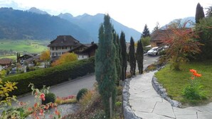 Un barrio residencial con casas, una carretera sinuosa y montañas al fondo.