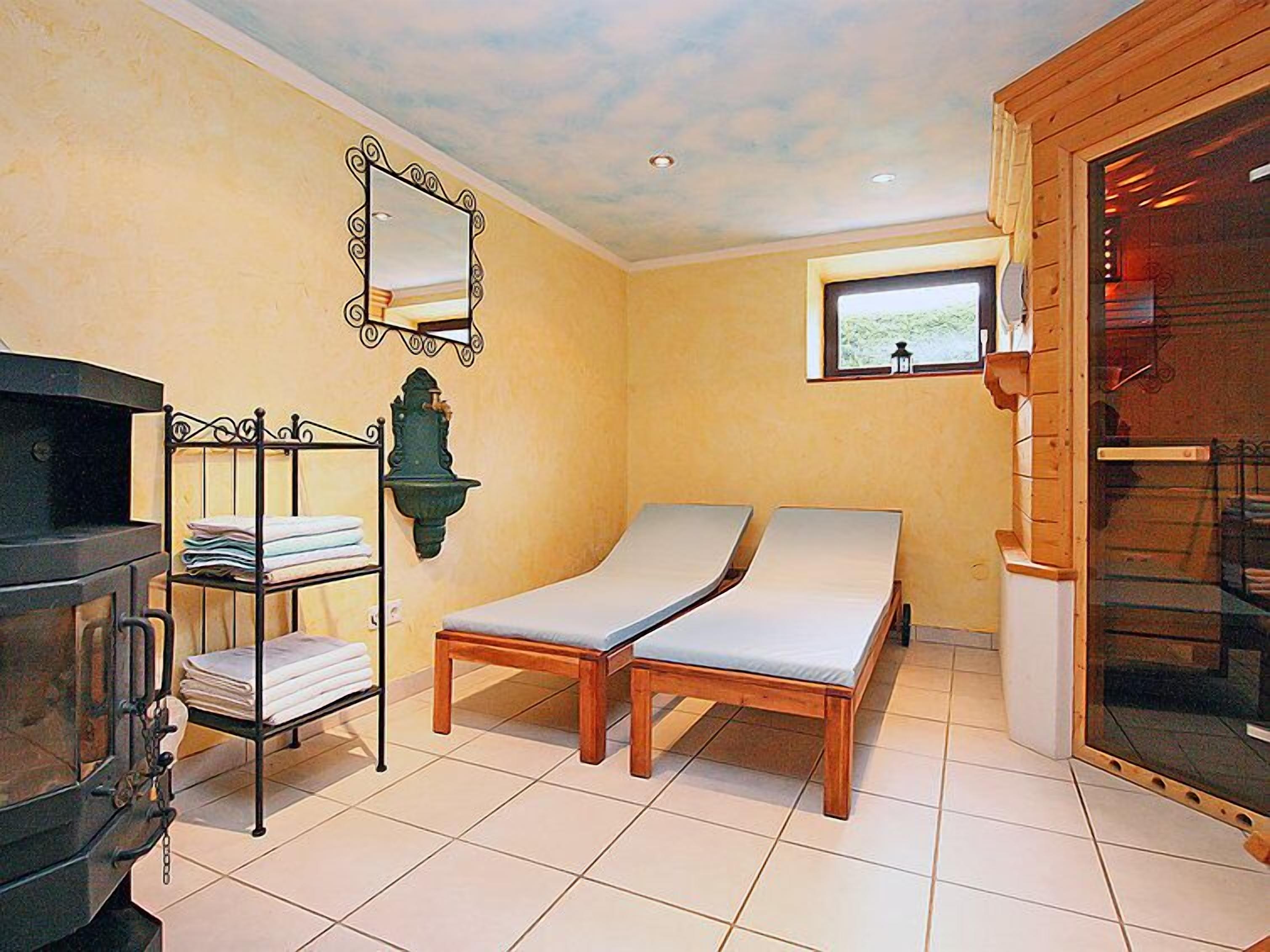 A room with a bed, a TV, a shelf with towels, and a window with a view.