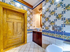 Ein Badezimmer mit Holztür, Waschbecken und Toilette.