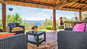 A covered outdoor seating area with wicker furniture, a small table, and a hanging planter.
