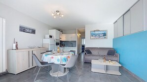 Ein kompakter Wohnbereich mit Essplatz, Küchenzeile und Sofa.