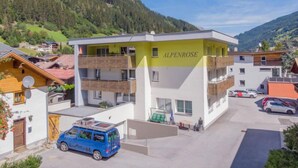 A multi-story building with the name "ALPENROSE" on the facade, surrounded by a mountainous landscape. - Alpenrose by Interhome (See)