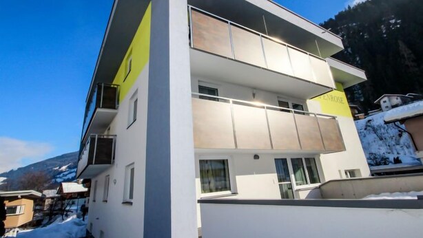 A modern two-story building with a balcony and a sign that reads "ENROSE". - Alpenrose by Interhome (See)