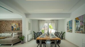 A modern dining room with a long table set for six, surrounded by chairs. - Vacation home Anđela by Interhome (Krk/Dobrinj)