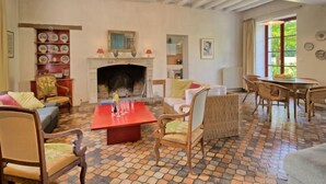 A cozy living room with a fireplace, a dining table, and comfortable seating.