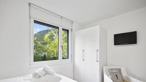 A bedroom with a bed, a chair, a wardrobe, and a TV. - Liebrand by Interhome (Churwalden)