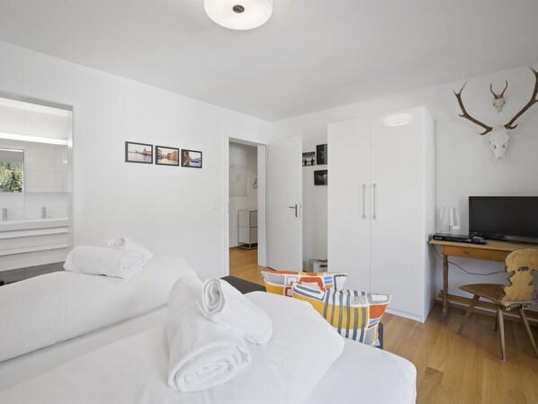 A modern hotel room with a large bed, a desk with a TV, and a wall-mounted deer skull decoration. - Liebrand by Interhome (Churwalden)