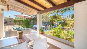 An outdoor patio with a pergola, tables, chairs, and a view of the garden. - Can Niu by Interhome (Pollença)