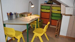 Une pièce comprenant un bureau, des chaises, une lampe et des tiroirs de rangement.