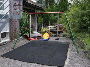 Ein Spielplatz mit Schaukeln und einer Fallschutzbelag-Unterfläche.
