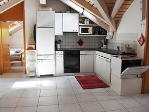 A compact kitchen with white cabinets, a black oven, a microwave, and a dishwasher.