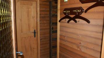 Un intérieur en bois avec une porte, un portail en métal et un porte-manteau fixé au mur.