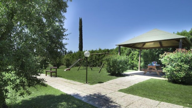 Ein Patio mit Schaukel, Picknicktisch und überdachter Sitzgruppe.
