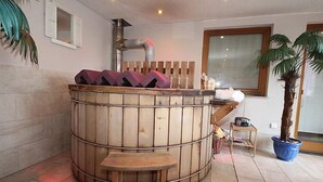 A spa area with a wooden hot tub, wooden benches, and a potted plant. - Apartment Anita by Interhome (Zell am Ziller)