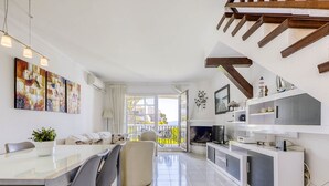 Une cuisine moderne avec un coin repas, un téléviseur et un balcon offrant une vue agréable.