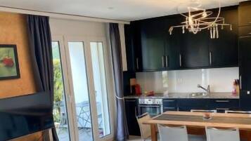 Een koelkast, een oven, een kinderstoel, kookgerei, borden en bestek