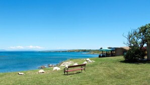 A grassy area with a bench, a gazebo, and a view of the sea. - Hilde Blue by Interhome (Medulin)
