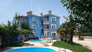 A hotel with a swimming pool, outdoor seating, and a blue building facade. - Hilde Blue by Interhome (Medulin)