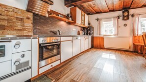 Una cocina moderna con vigas de madera, un salpicadero de piedra y electrodomésticos de acero inoxidable.