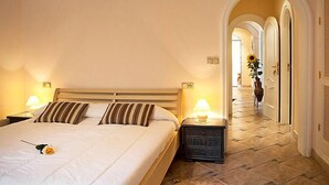 A hotel room with a bed, bedside lamps, a nightstand, and an air conditioning unit. - Vacation home Calina by Interhome (Benissa)