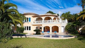 A large, multi-story house with a pool, surrounded by palm trees and a well-maintained lawn. - Vacation home Calina by Interhome (Benissa)
